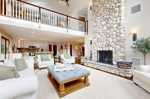a living room with a large stone fireplace at Bird's Paradise in Oak Bluffs