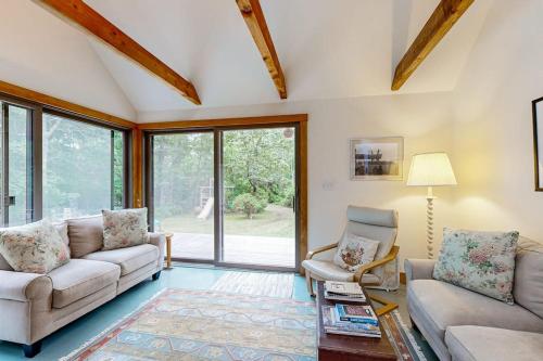 a living room with two couches and a table at Chilmark Guest House in Chilmark