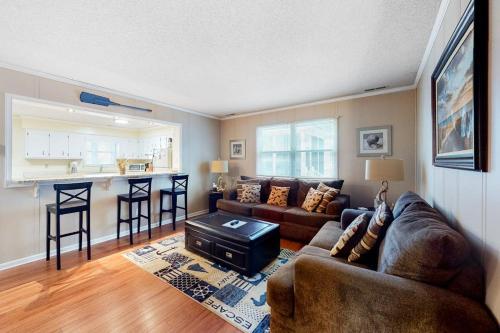 a living room with a couch and a kitchen at Stop And Relax in Ocean Pines