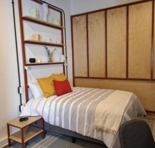 a bedroom with a bed with yellow and red pillows at Casa Tabacalera in Mexico City