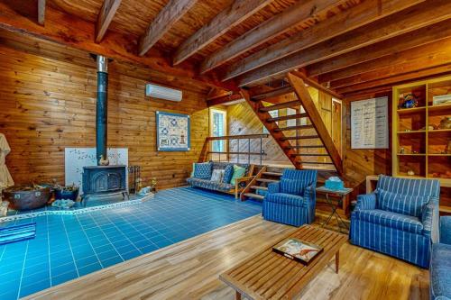 a living room with a fireplace in a log cabin at Cozy Island Cabin in Edgartown
