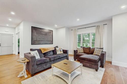 a living room with two couches and a table at Heritage Escape in Mashpee