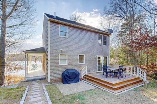 a house with a deck and a table on it at Pond View Getaway in Sandwich
