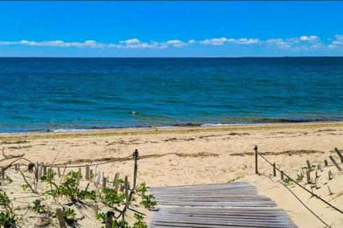 a wooden pathway to the beach with the ocean at Seas The Day in North Truro