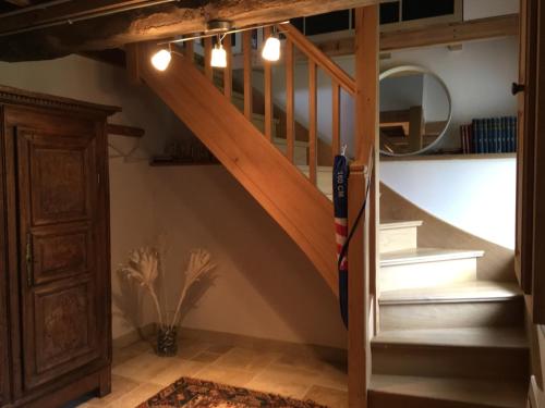 a wooden staircase in a room with a mirror at Studio des Perriots in Englesqueville-la-Percée