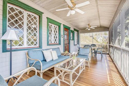 a porch with blue chairs and a ceiling fan at Anna's Cottage in Saugatuck