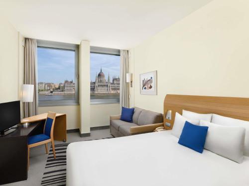 a hotel room with a bed and a view of the city at Novotel Budapest Danube in Budapest
