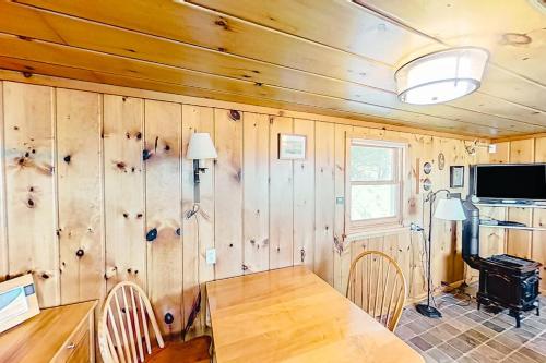 a dining room with a table and chairs and wooden walls at Dune Grass Shores in Beulah