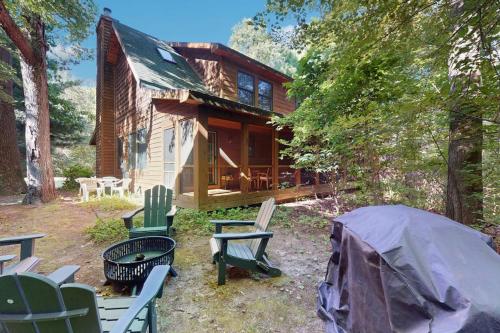 a cabin in the woods with chairs and a tent at Kingfisher Cove Cabin 19 in Saugatuck
