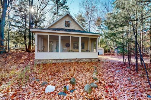 a small house in the woods with leaves on the ground at Uncle Warren's Retreat in Glen Arbor