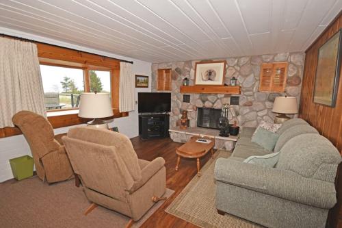 a living room with a couch and chairs and a fireplace at Ships Haven in Glen Arbor