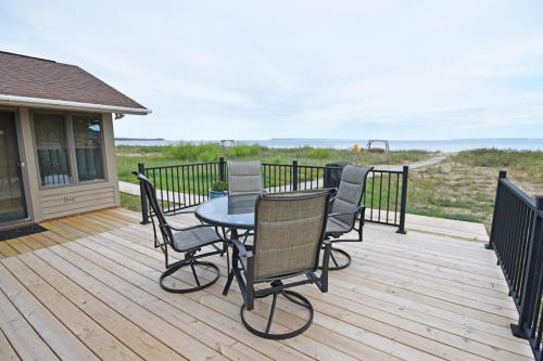a patio with a table and chairs on a deck at Ships Haven in Glen Arbor