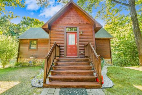 a wooden cabin with a staircase leading to a red door at The Stonewater Lodge in Traverse City