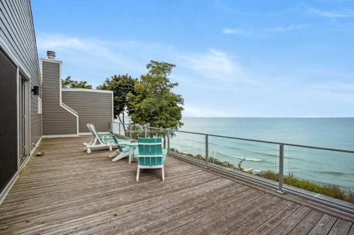 a wooden deck with chairs and a table and the ocean at Leisure On The Lake in New Buffalo