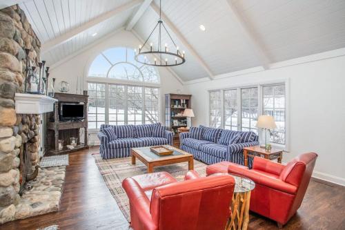 a living room with couches and a stone fireplace at Point Cottage at Point O' Woods in Benton Harbor