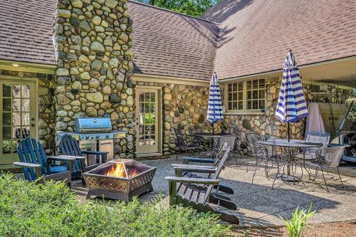a patio with tables and chairs and a fire pit at Point Cottage at Point O' Woods in Benton Harbor