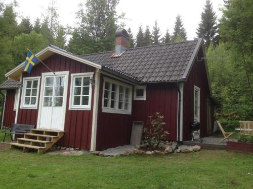 a red tiny house with a flag on it at Stuga i Ullared in Ullared