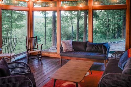 a living room with a couch and chairs in a cabin at Sorellina House in Maple City