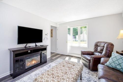 a living room with a fireplace and a flat screen tv at Harbor Charm in Harbor Springs