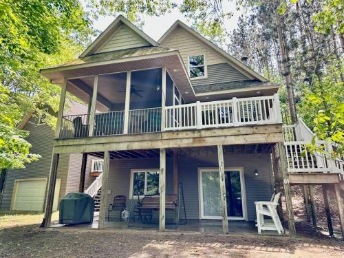 a house with a wrap around porch with a deck at Beach House in Saugatuck