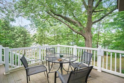 a table and chairs on a deck with a tree at Beach House in Saugatuck
