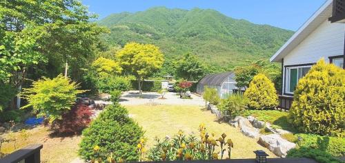 a garden in front of a house with a mountain at danyang deulggochyanggi in Danyang