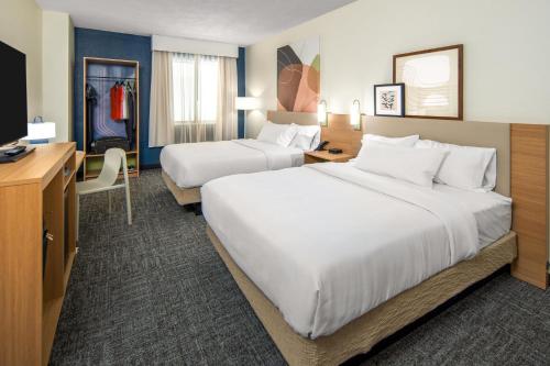 a hotel room with two beds and a desk at Spark By Hilton Staunton in Staunton