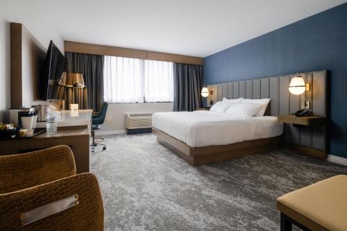 a hotel room with a bed and a desk at The Strathallan Rochester Hotel & Spa, Tapestry by Hilton in Rochester