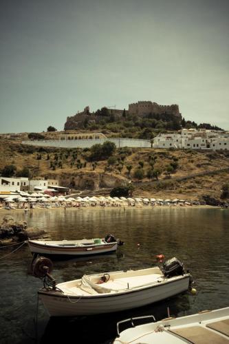 two boats are docked in a body of water at Lindos Panorama in Líndos