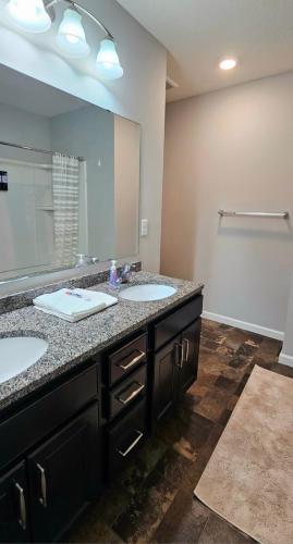 a bathroom with two sinks and a large mirror at River Valley Stay in Eagan