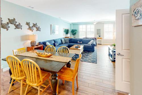 a living room with a table and a blue couch at The Sanctuary - Summer Breeze A114 in Virginia Beach