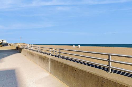 a walkway next to a beach with a fence at The Sanctuary - Blue Lagoon A323 in Virginia Beach