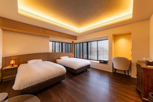 a bedroom with two beds and a table and chairs at 貞芙庵 in Ichinomiya