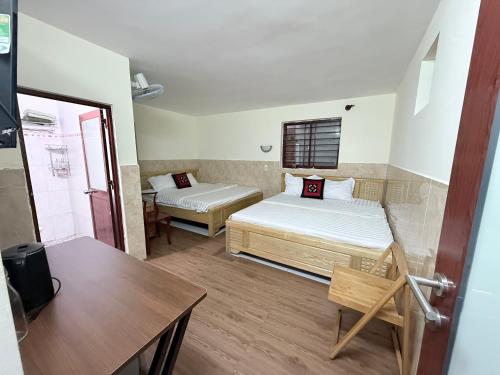a small room with two beds and a table at Ba Doan 2 in Con Dao