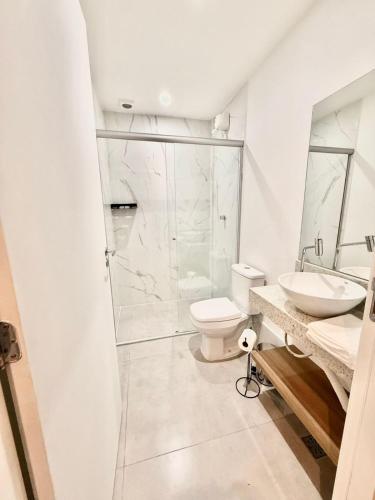 a white bathroom with a toilet and a sink at Premium Office-My Stay 09 in Brasília