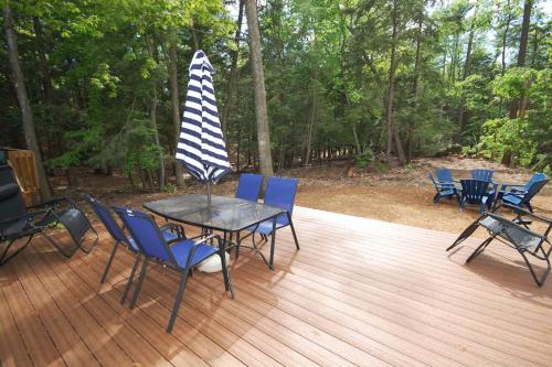 a table with chairs and an umbrella on a deck at Dunes Trail in Glen Arbor