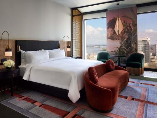 a bedroom with a bed and a chair and a large window at FAIRMONT NEW ORLEANS in New Orleans