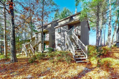 a house with stairs leading up to it in the woods at Hawks Nest 58 in Glen Arbor
