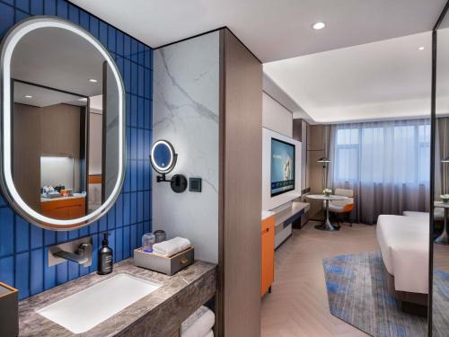 a bathroom with a sink and a mirror at Novotel Changshu Yushan in Changshu