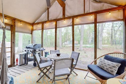 a screened in porch with a grill and chairs at Livywood Cottage in New Buffalo