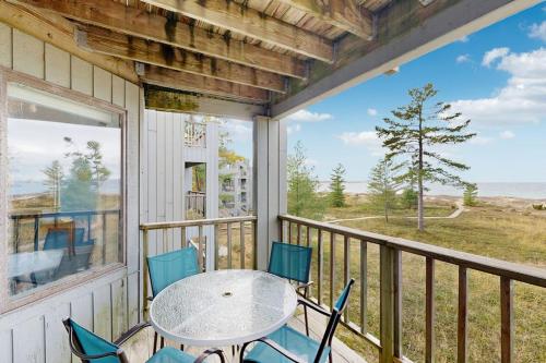 a patio with a table and chairs on a balcony at South Beach 43 in Glen Arbor