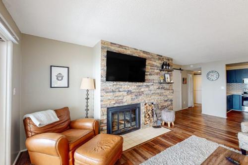 a living room with a fireplace with a flat screen tv at Ship Watch 15 in Glen Arbor