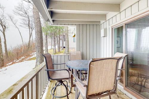 a porch with two chairs and a table on a balcony at Ship Watch 15 in Glen Arbor