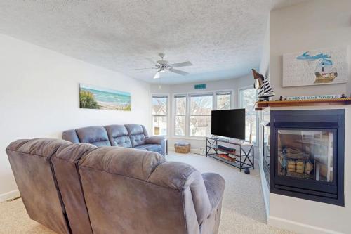 a living room with a couch and a fireplace at Northern Michigan Manistee Magic in Manistee