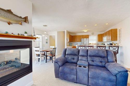 a living room with a blue couch and a fireplace at Northern Michigan Manistee Magic in Manistee