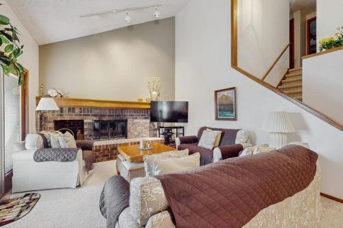 a living room with a couch and a fireplace at Ski & Tee Boyne Highlands Townhouse in Harbor Springs