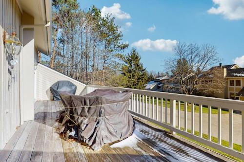 a chair sitting on a deck on a house at Ski & Tee Boyne Highlands Townhouse in Harbor Springs