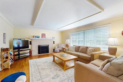 a living room with a couch and a tv at Wine Down Cottage in Union Pier
