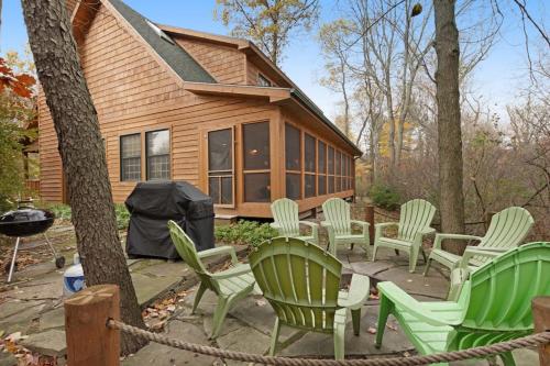 a group of green chairs in front of a house at Kingfisher Cove Cabin 2 in Saugatuck