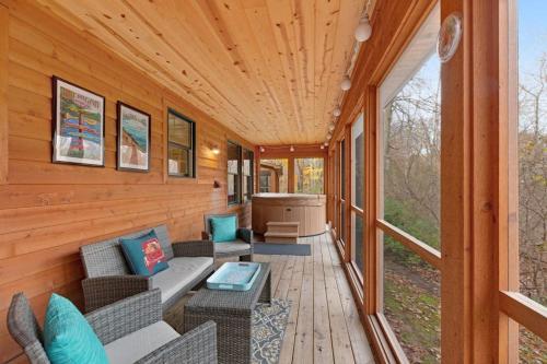 a screened in porch with a couch and chairs at Kingfisher Cove Cabin 2 in Saugatuck